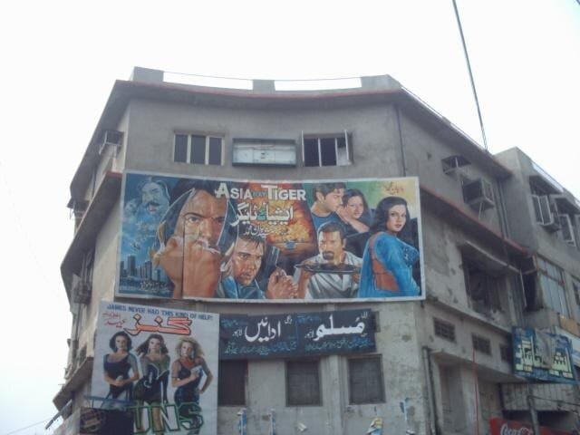 Billboard film Lollywood modern dengan judul film terbaru, mencerminkan industri film Pakistan