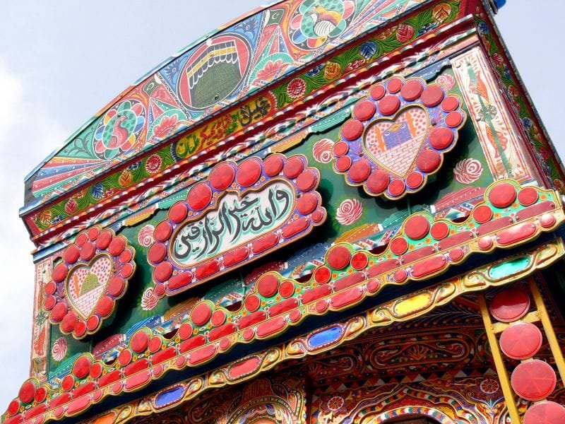 Detail lukisan kaligrafi dan simbol spiritual pada bodi truk di Pakistan
