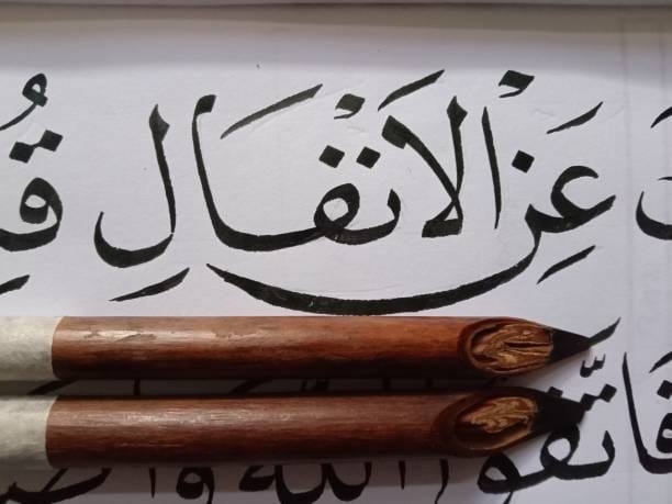 Seorang seniman kaligrafi Pakistan sedang menulis indah ayat Al-Qur'an, menunjukkan dedikasi seni Islam