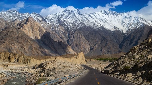 Pemandangan udara Karakoram Death Road yang ekstrem melintasi pegunungan tinggi bersalju